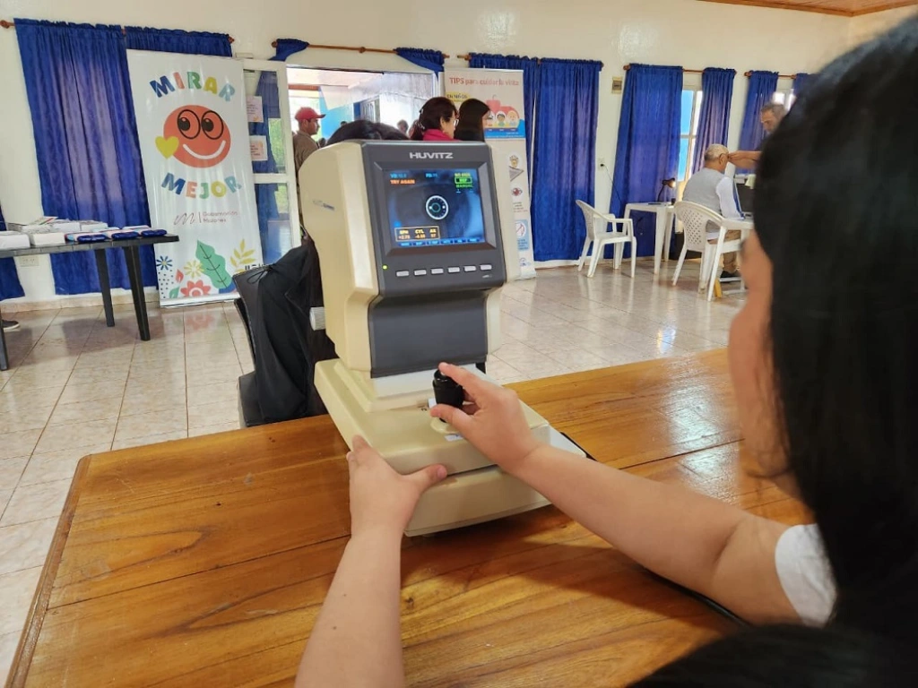 oftalmóloga controla la vista de un vecino usando un autorefractómetro.