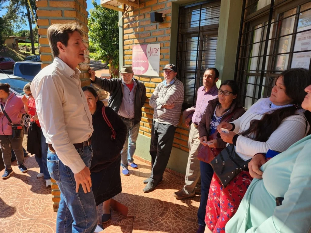 Héctor Decut charla con un grupo de vecinos mientras esperan a ser atendidos.