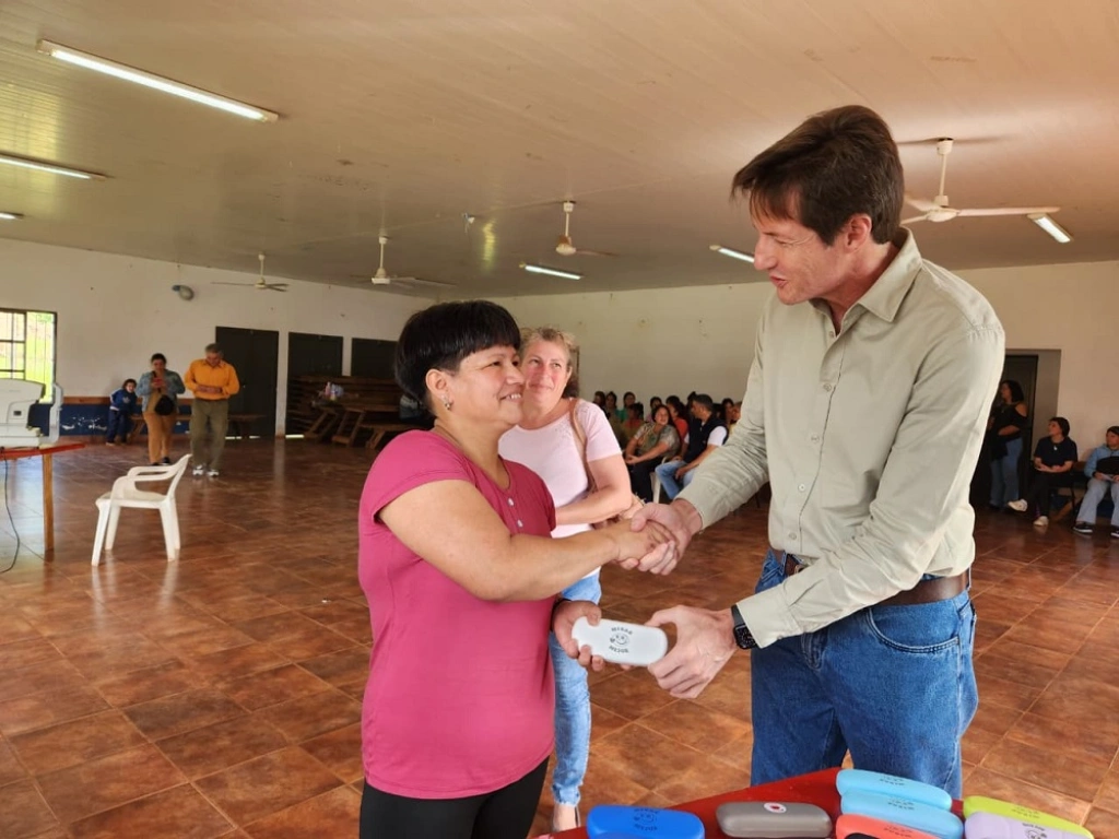 Héctor Decut entrega sus nuevos anteojos de Mirar Mejor a una vecina.