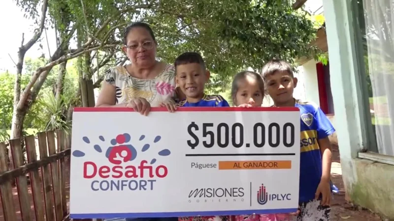 Julia junto a tres de sus nietos felices con su cheque. Pagar cuentas y comprar regalos, el destino del premio.