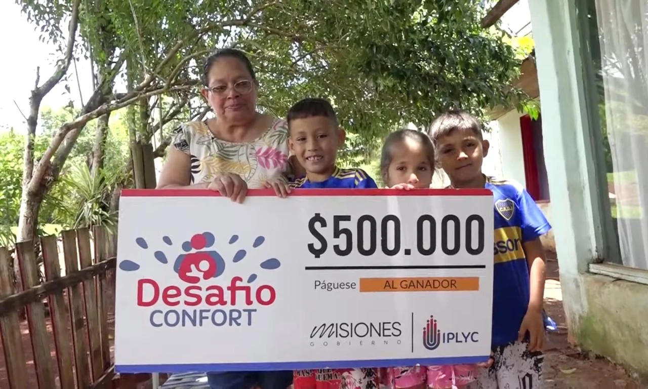Julia junto a tres de sus nietos felices con su cheque. Pagar cuentas y comprar regalos, el destino del premio.