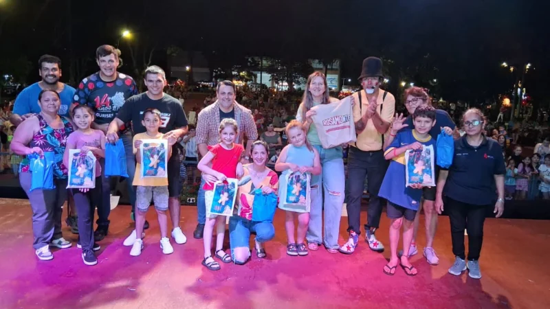 Equipo de Gurises Felices junto a niños con sus obsequios, en el escenario de Navidad en Capioví.