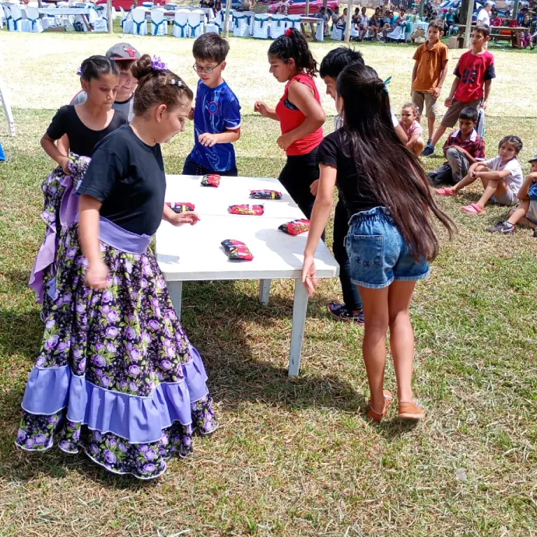 Niños realizan juego alrededor de una mesa. Gurises Felices en Santiago De Liniers.