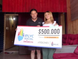 Agustina junto a su papá felices con su cheque. Con el dinero planea iniciar un emprendimiento.