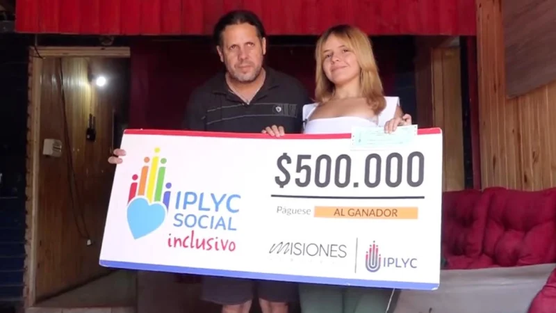 Agustina junto a su papá felices con su cheque. Con el dinero planea iniciar un emprendimiento.