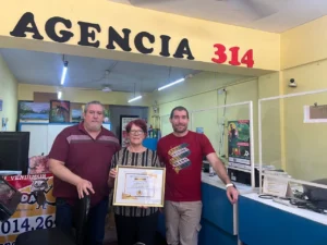 Amalia junto a sus hijos, en su agencia distinguida por su antigüedad y entrega de premios.