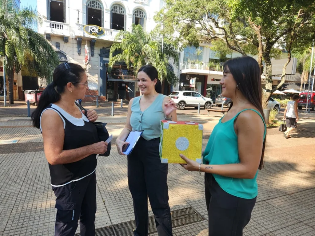 Gabriela Peralta y Marisa Seewald charlan y juegan con una vecina en la plaza.