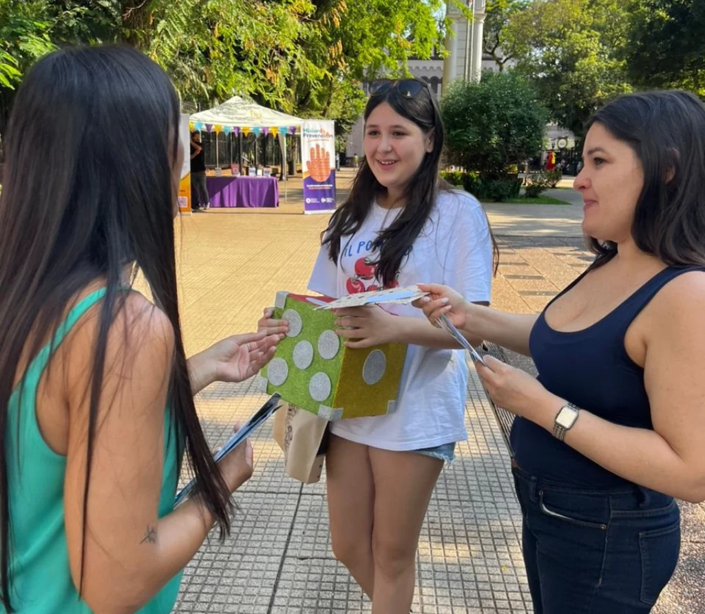 Marisa Seewald realiza un juego con dos adolescentes en la plaza 9 De Julio.