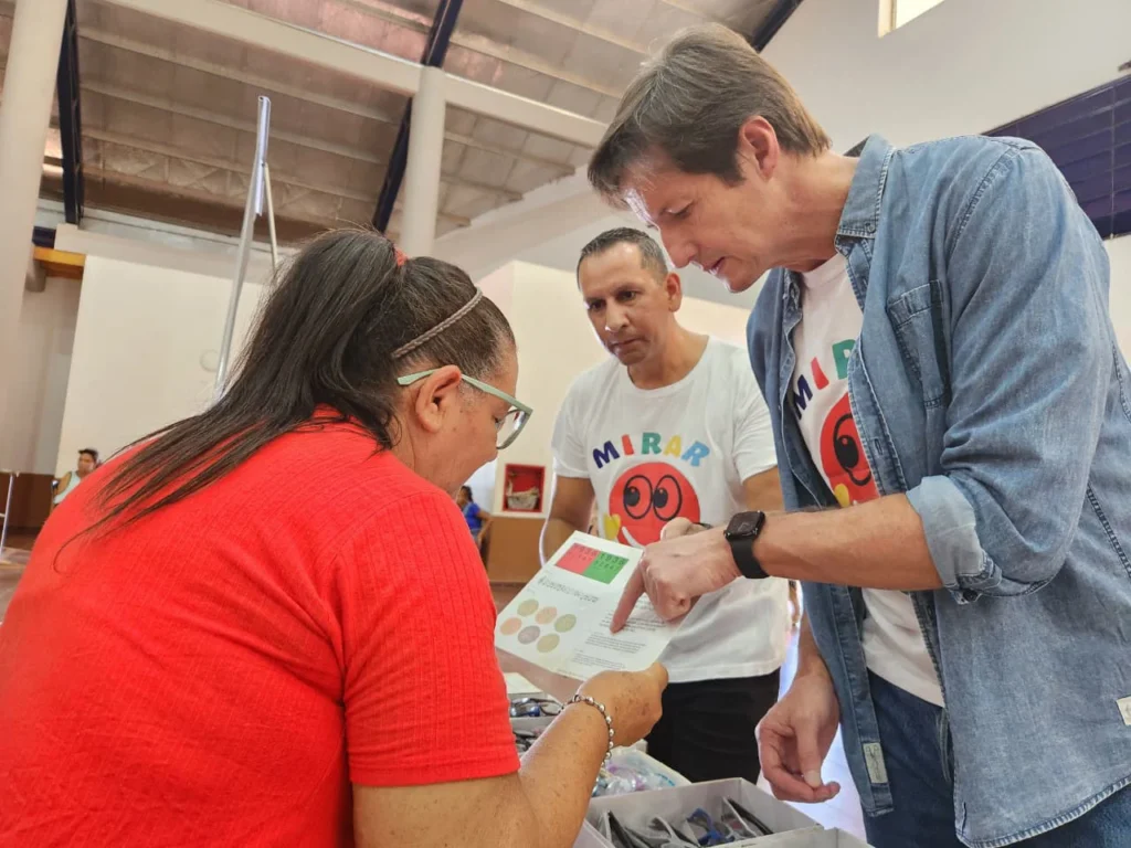 Héctor Decut ayuda a leer un texto de prueba a una vecina de Cerro Azul.