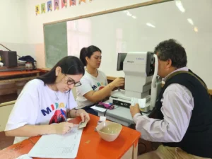Oftalmóloga revisa los ojos de un vecino con autorefractómetro. Mirar Mejor en Jardín América.