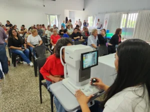 Oftalmóloga revisa los ojos de una vecina con un autorefractómetro. Mirar Mejor - Almafuerte.