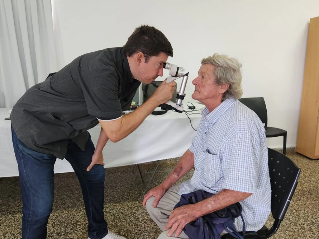 Oftalmólogo usa un tonómetro para medir la presión ocular de un vecino de Almafuerte.