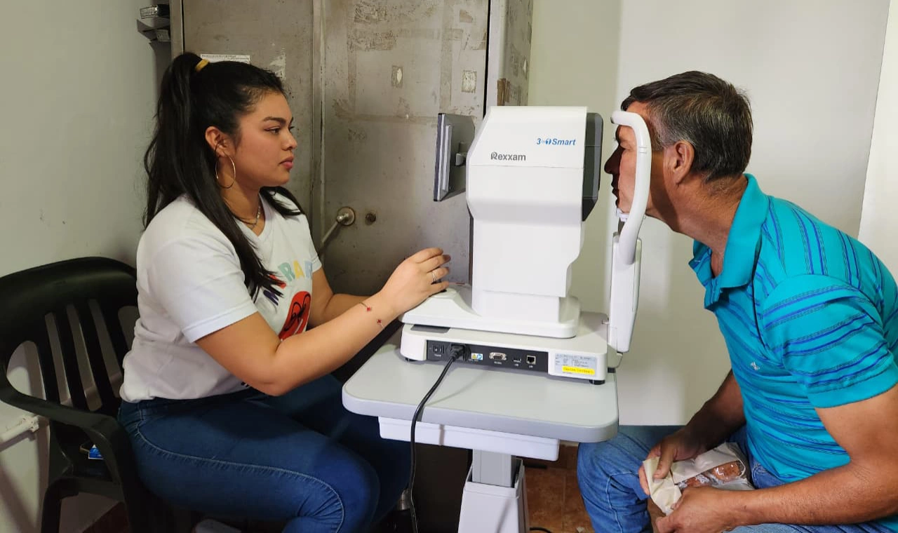 Oftalmóloga revisa los ojos de un vecino con un autorefractómetro. Mirar Mejor - Cerro Corá.