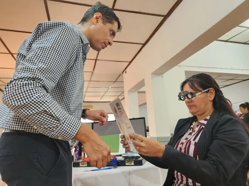 Vecina de San Javier lee un texto con lentes graduados y la ayuda de un oftalmólogo.