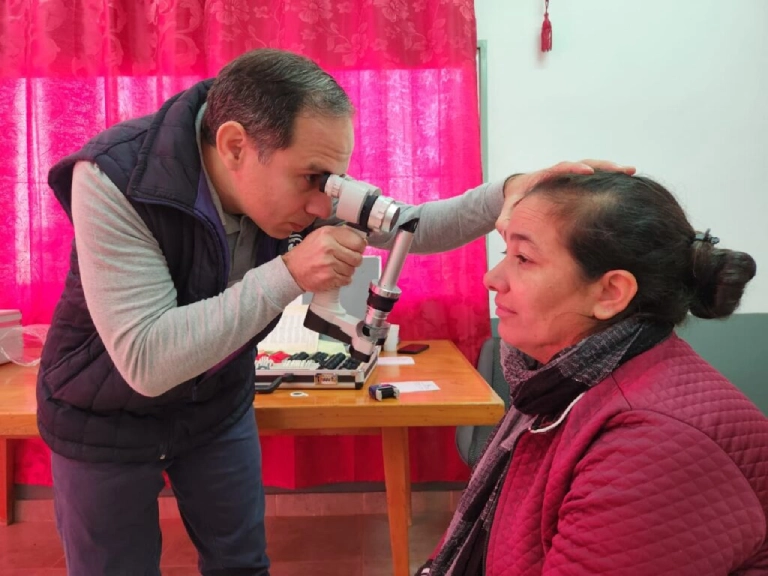 Oftalmólogo usa un tonómetro para medir la presión ocular de una vecina de Arroyo Del Medio.