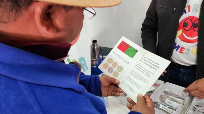 Vecino lee un texto de prueba con sus nuevos anteojo de Mirar Mejor, en Arroyo Del Medio.