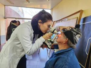 Oftalmóloga usa un tonómetro para medir la presión ocular de un vecino. Mirar Mejor en Campo Grande.