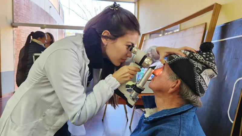 Oftalmóloga usa un tonómetro para medir la presión ocular de un vecino. Mirar Mejor en Campo Grande.