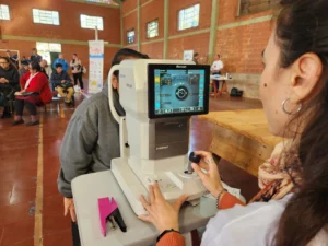 Oftalmóloga revisa la visión de una vecina mediante autorrefractómetro. Mirar Mejor - Hipólito Yrigoyen.