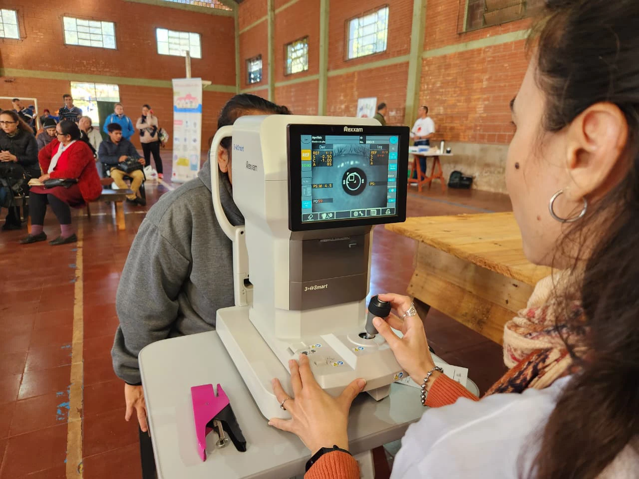 Oftalmóloga revisa la visión de una vecina mediante autorrefractómetro. Mirar Mejor - Hipólito Yrigoyen.