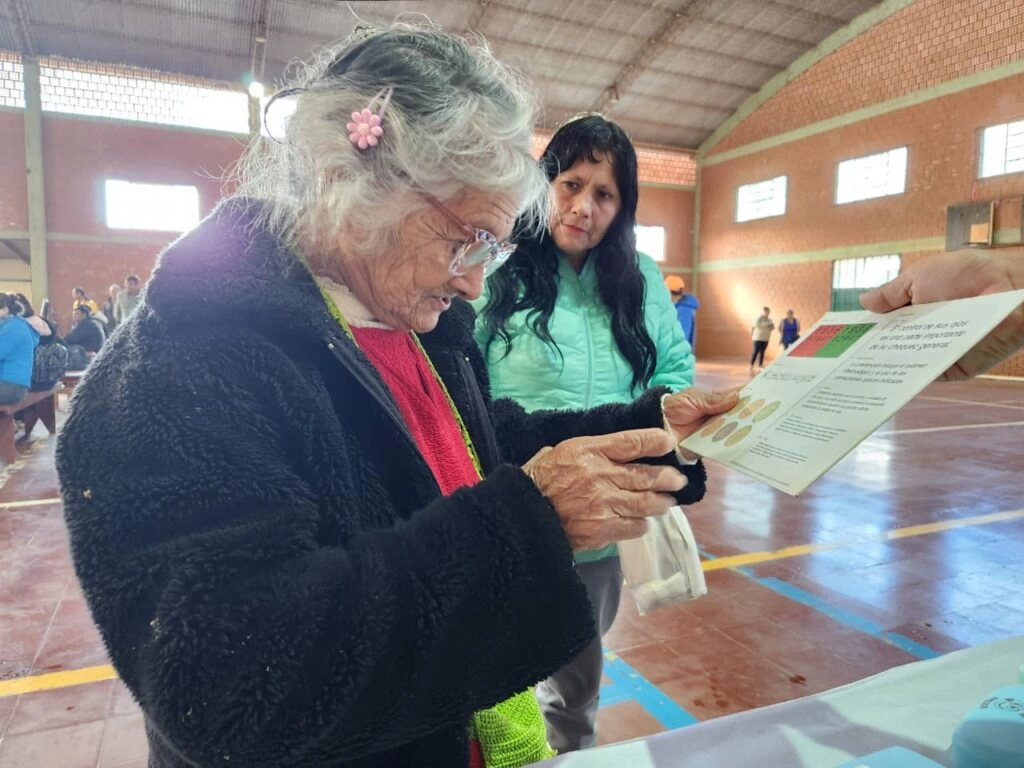 Vecina mayor lee un texto de prueba con sus nuevos anteojos de Mirar Mejor en Hipólito Yrigoyen.