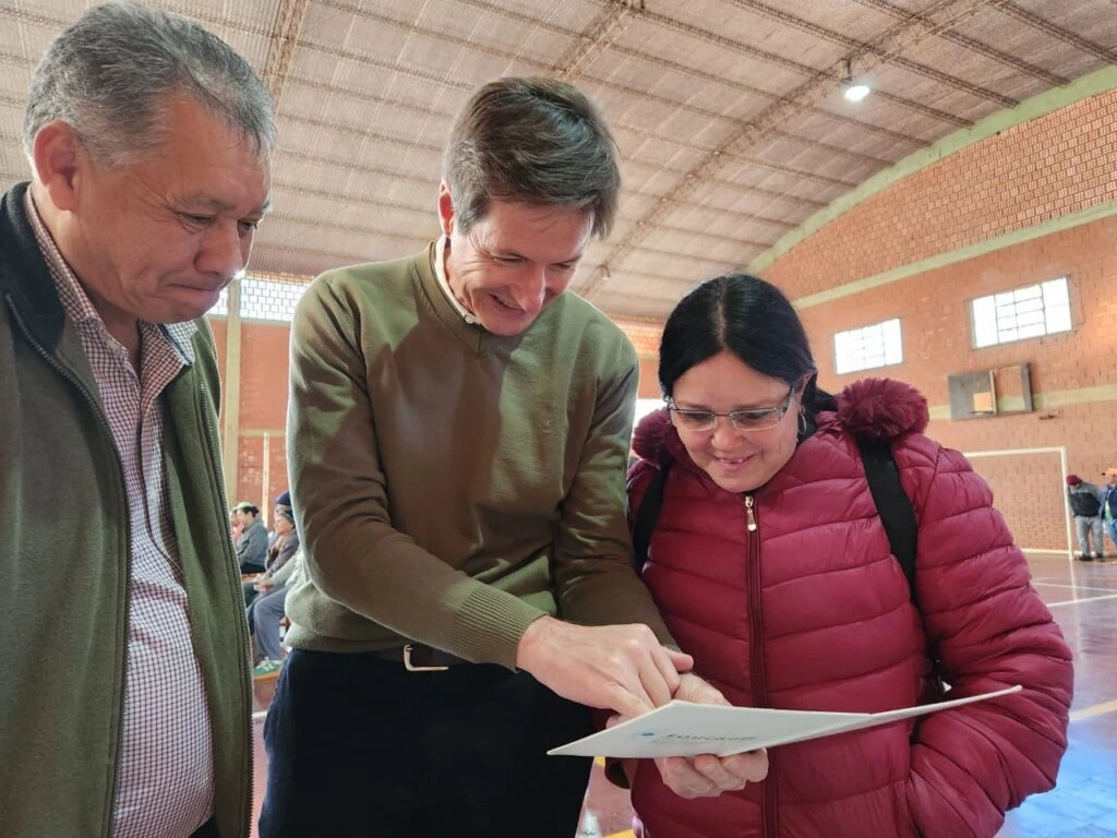 Vecina lee un texto de prueba con sus nuevos anteojos y la ayuda de Héctor Decut.