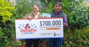 Raúl y su esposa sonríen con su cheque. Comprará materiales para arreglar su casa.