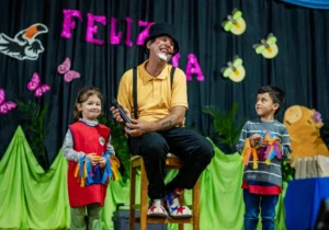 Dos niños participan con Poca Sopa en el escenario. Fiesta de los Jardines de Infantes - Jardín América.