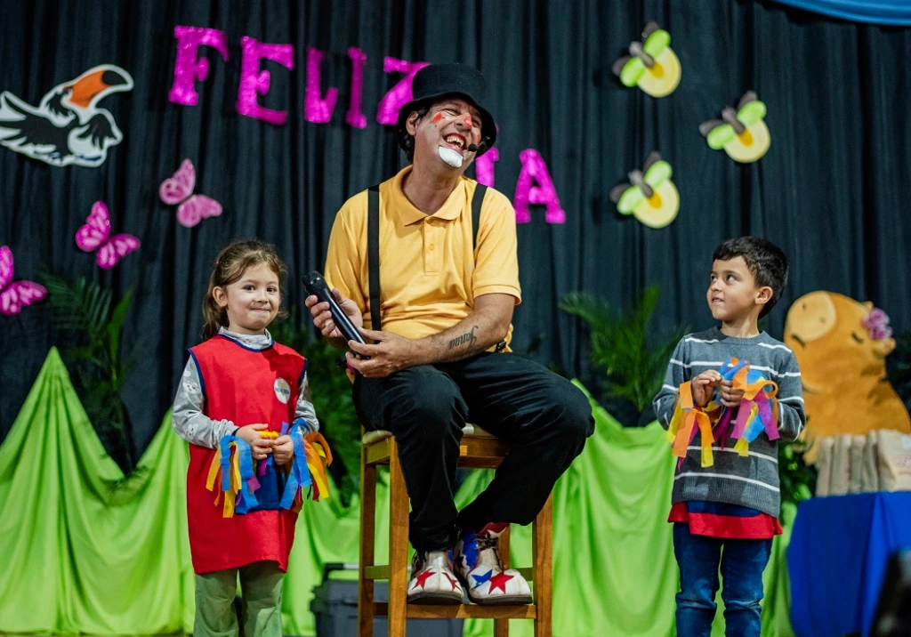 Dos niños participan con Poca Sopa en el escenario. Fiesta de los Jardines de Infantes - Jardín América.