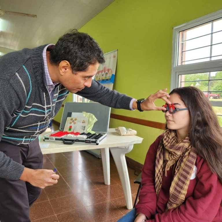 Oftalmólogo prueba lentes graduados a una adolescente de Dos Arroyos. Mirar Mejor