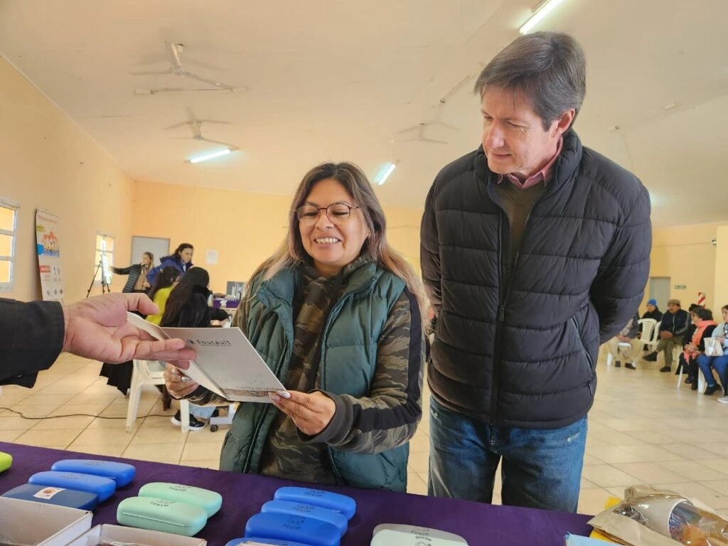 Héctor Rojas Decut charla con una vecina que lee un texto de prueba con sus nuevos anteojos.