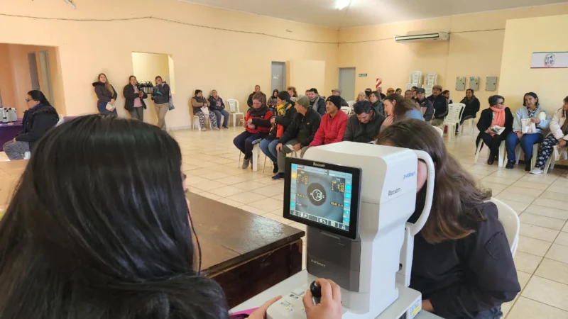 Oftalmóloga revisa los ojos de una vecina mediante un autorefractómetro. Mirar Mejor en Profundidad.