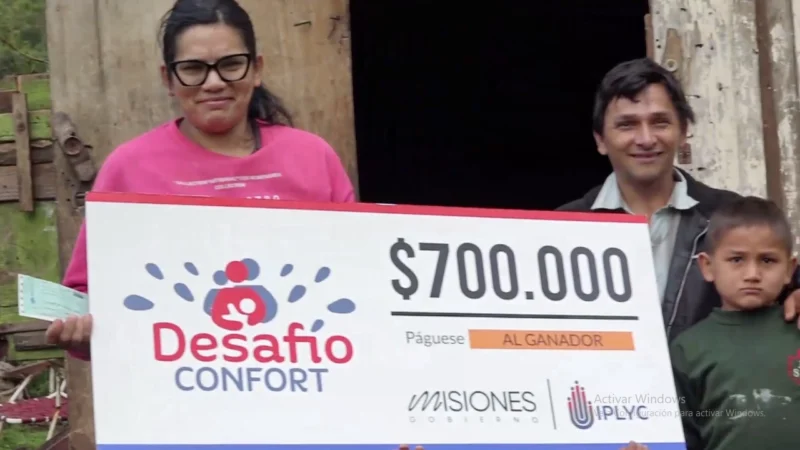 Marcela y su familia sonríen con su cheque de Desafío Confort. El dinero lo destinará a refacciones en su casa.