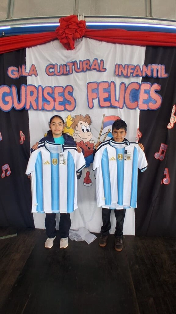 Una niña y un niño con sus camisetas de la Selección Argentina. Obsequio de Gurises Felices.