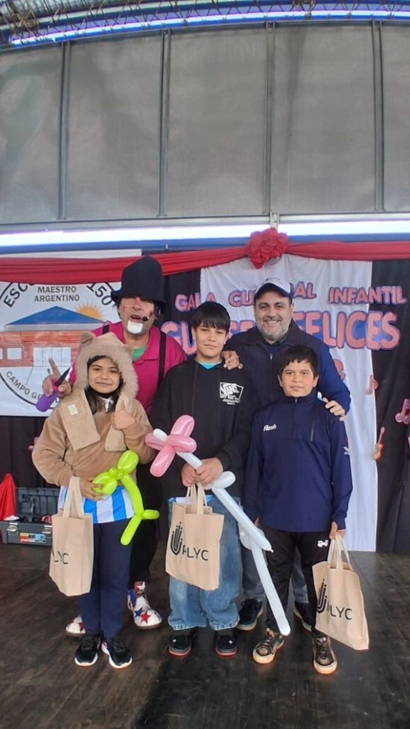 Poca Sopa y Marcelo Ledesma junto a tres niños que sonríen con sus premios.