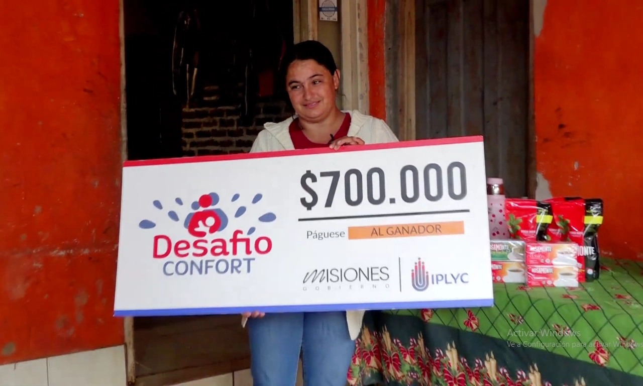 Patricia sonríe con su cheque. El dinero del Desafío es para terminar la habitación de sus hijos.