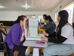 Oftalmóloga revisa los ojos de una vecina mediante un autorefractómetro. Mártires, Operativo Mirar Mejor.