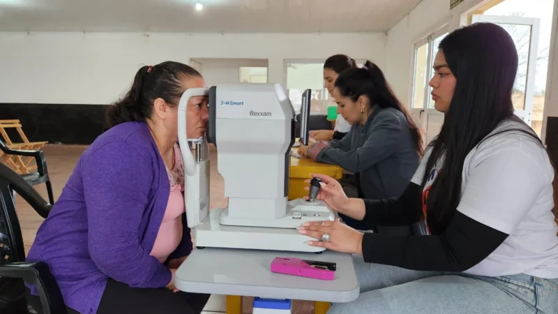 Oftalmóloga revisa los ojos de una vecina mediante un autorefractómetro. Mártires, Operativo Mirar Mejor.