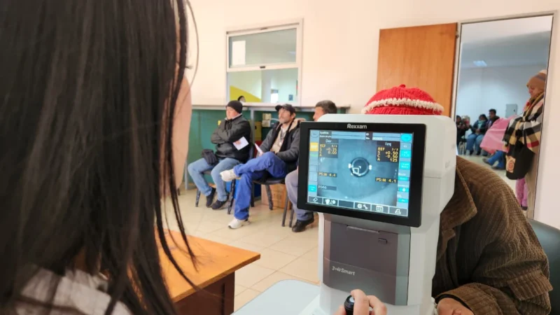 Oftalmóloga revisa los ojos de una vecina mayor mediante un autorefractómetro. Mirar Mejor en Puerto Leoni.