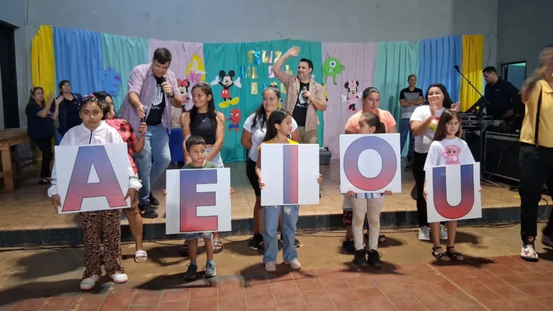 Niños y equipo de Gurises Felices realizan juego con letras gigantes. Mes de la niñez.