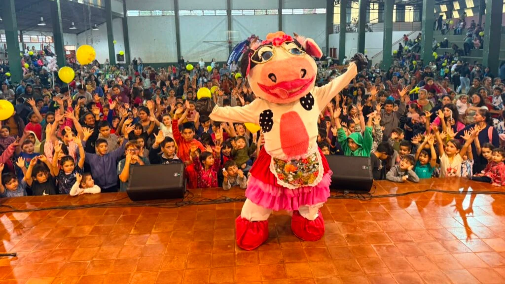 Foto grupal de La Vaca Lola y multitud de niños en Corpus.