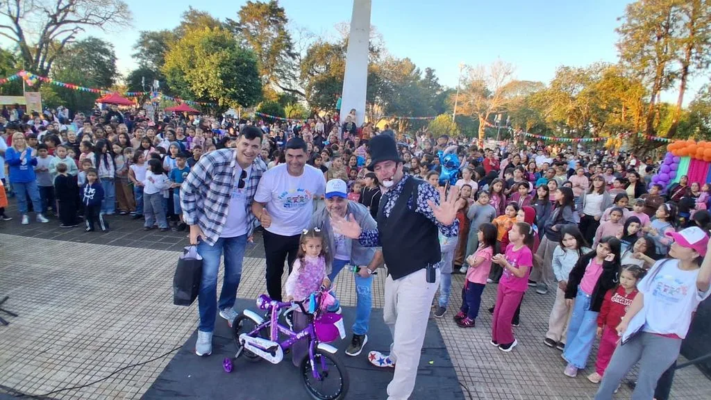 Niña cun una bicicleta de obsequio junto al equipo de Gurises y el multitudinario público presente.