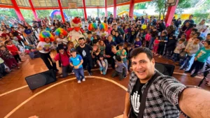 Foto selfie equipo de Gurises y multitud de niños que vivieron una tarde de diversión y aprendizaje en Santo Pipó.