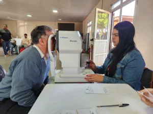 Oftalmóloga revisa los ojos de un vecino mediante un autorefractómetro. Mirar Mejor en Garuhapé.