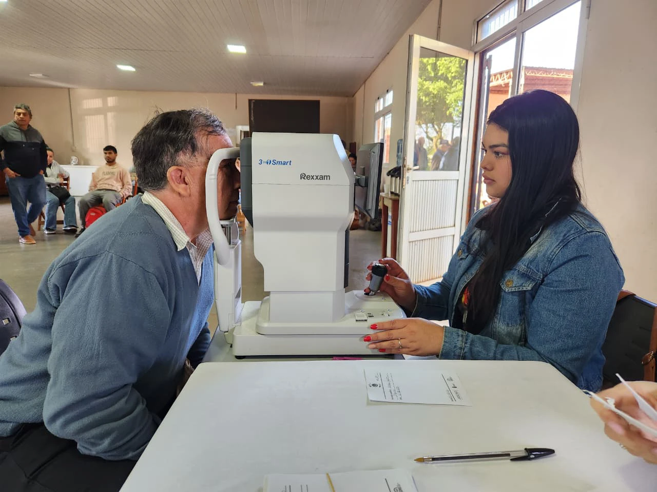 Oftalmóloga revisa los ojos de un vecino mediante un autorefractómetro. Mirar Mejor en Garuhapé.