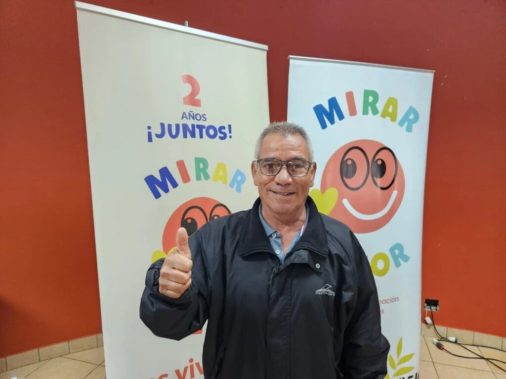 Vecino saluda pulgar arriba luciendo sonriente sus nuevos anteojos de Mirar Mejor.