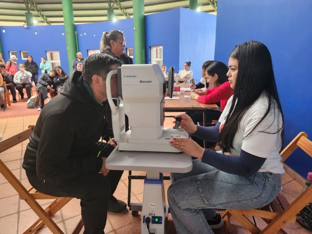 Oftalmóloga revisa los ojos de un vecino mediante un autorefractómetro. Mirar Mejor en Puerto Rico.