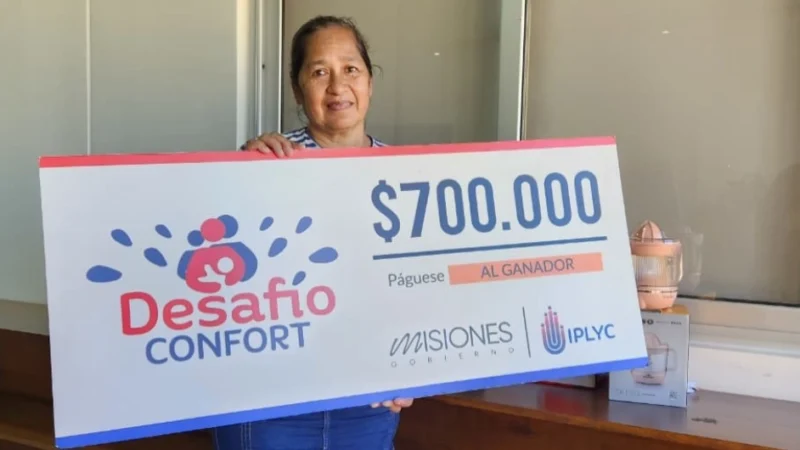 Norma sonríe con su cheque. Con este premio podrá pagar deudas.