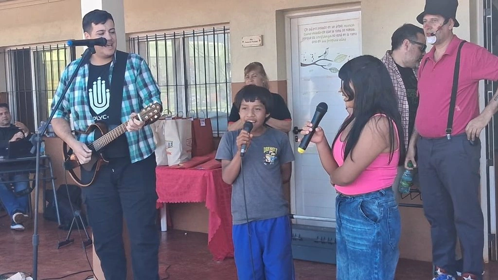 Un niño de la comunidad canta acompañado por los músicos de Gurises Felices. 