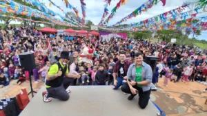 Foto grupal del equipo de Gurises Felices y una multitud de público infantil y familiar, en Pozo Azul.